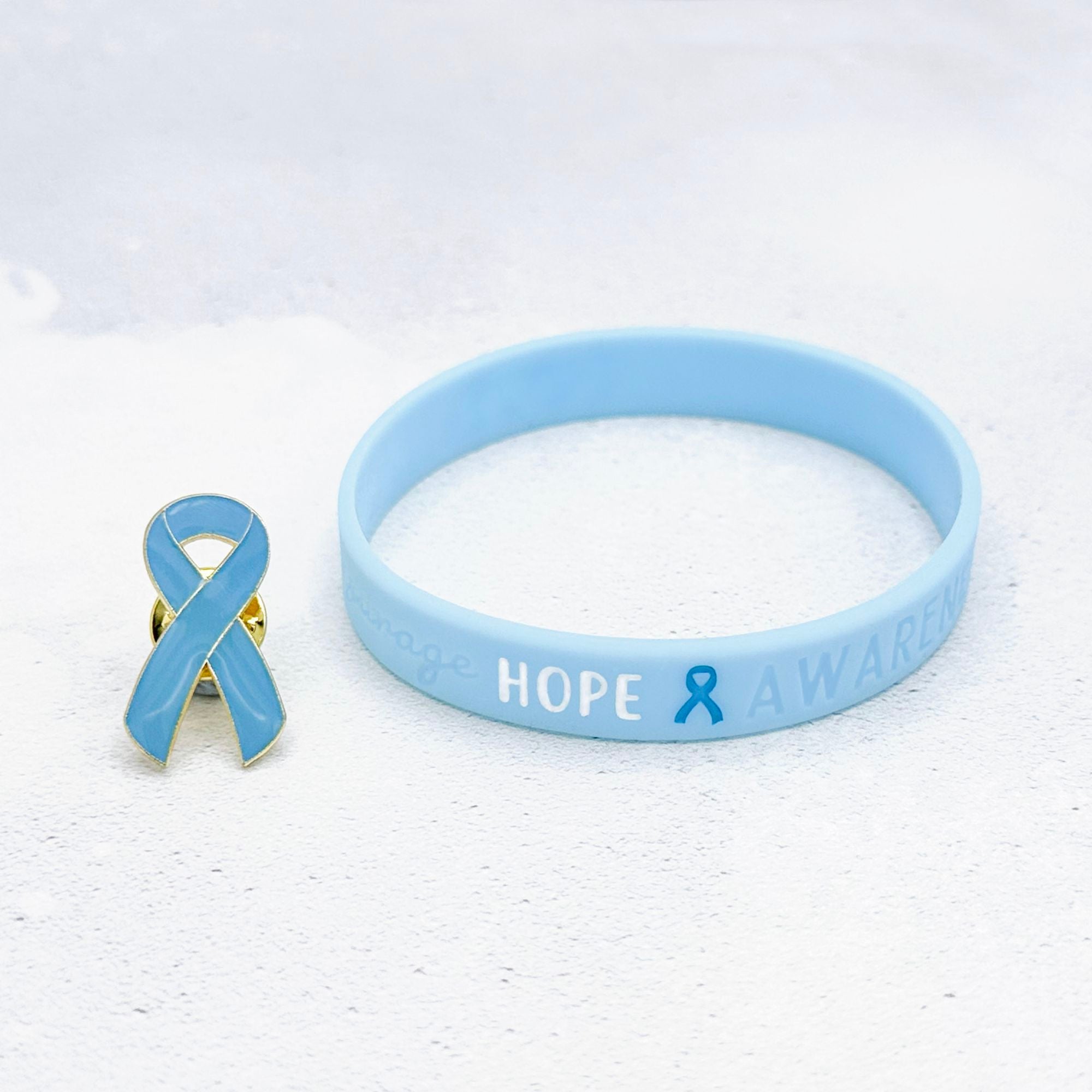 light blue awareness ribbon pin and wristband for addison's disease support