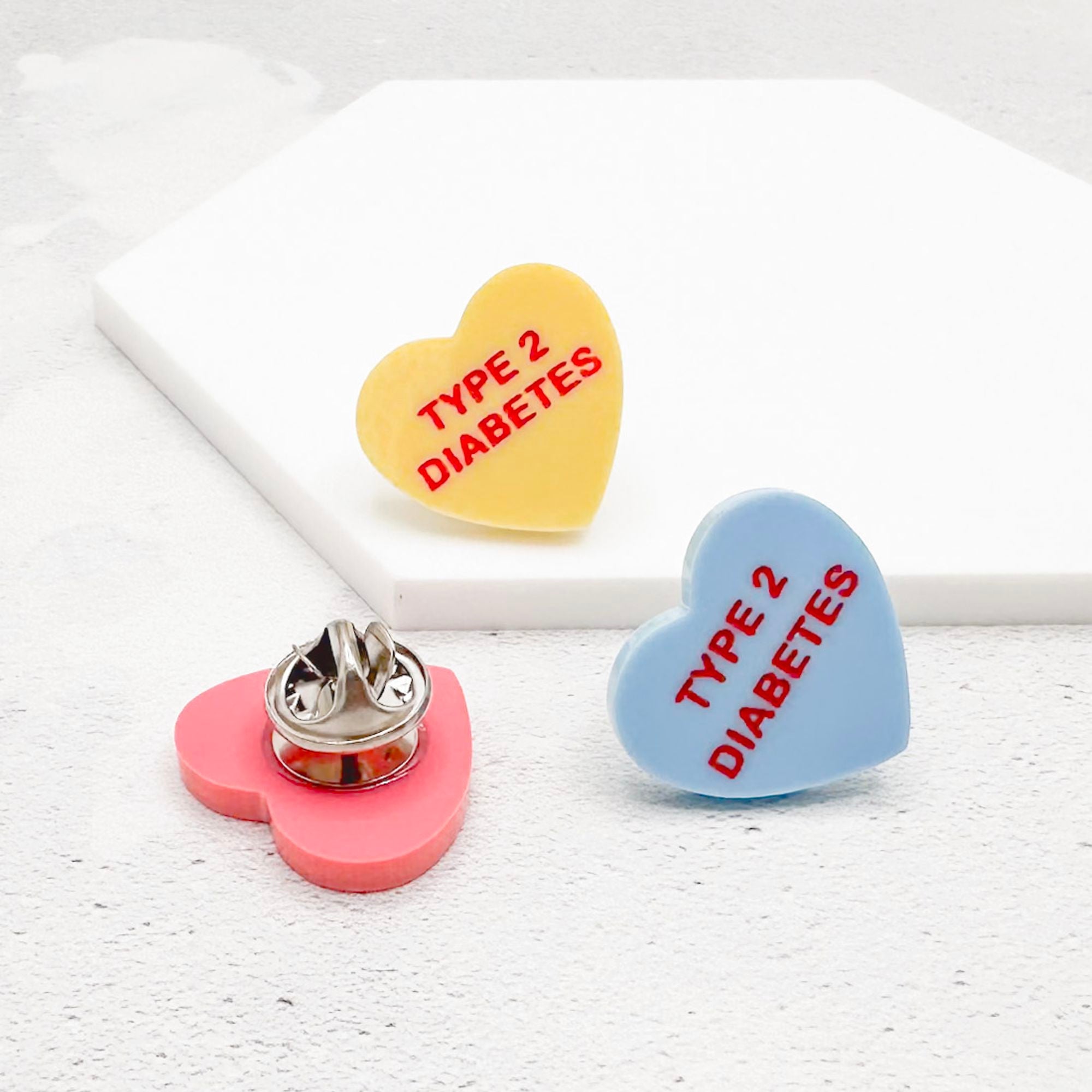 type 2 diabetes acrylic heart pins in yellow, blue, and pink