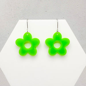 Flower-shaped green earrings on a white and gray background
