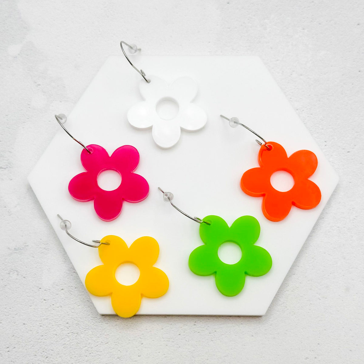 Hippie style flower earrings in multiple colours on a white background