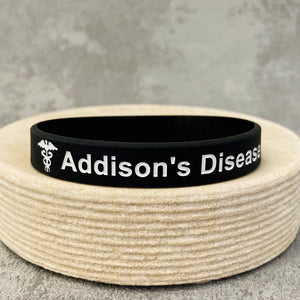 Black wristband with 'Addison's Disease' text in white on a textured surface