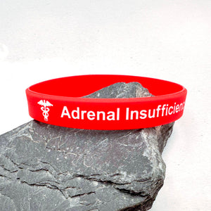 Red medical wristband with 'Adrenal Insufficiency' text