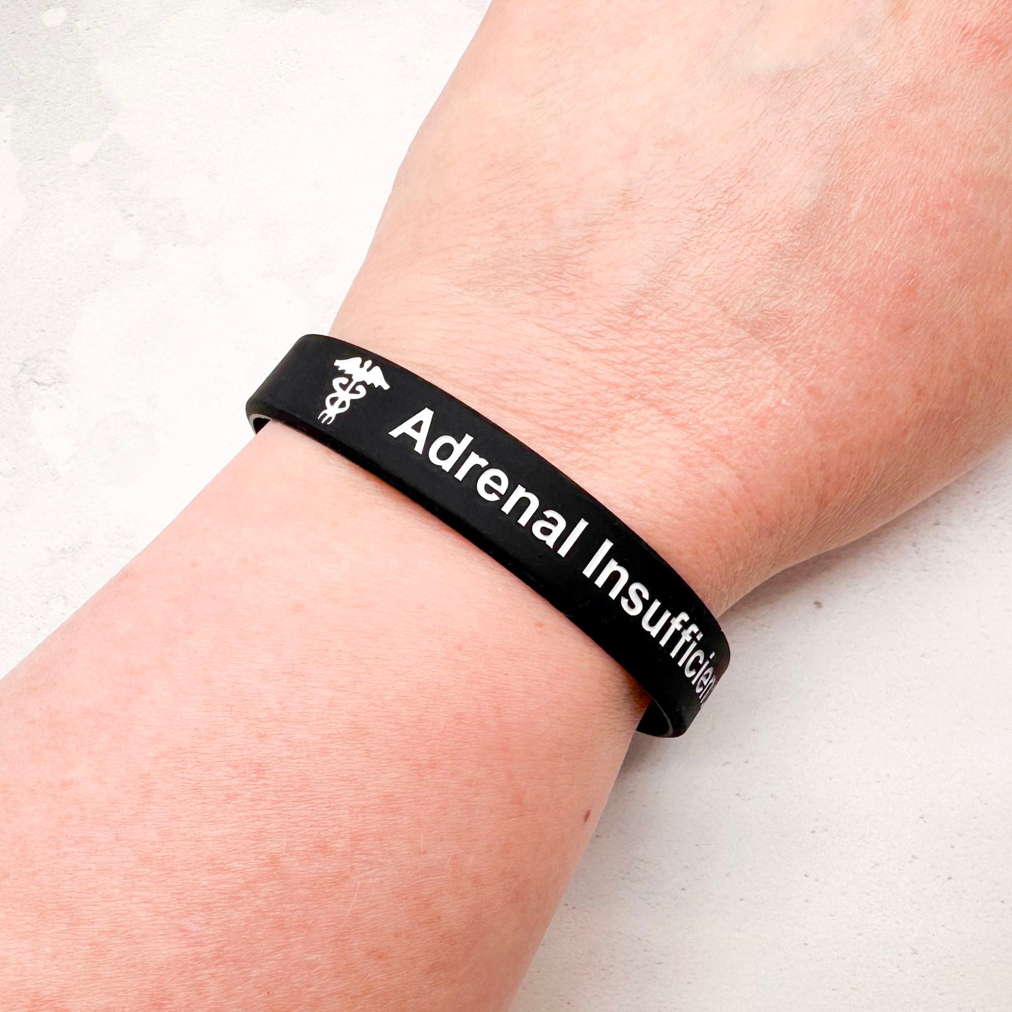 Black silicone adrenal insufficiency medical alert wristband worn on wrist