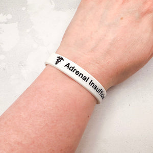 White silicone adrenal insufficiency medical alert wristband worn on wrist