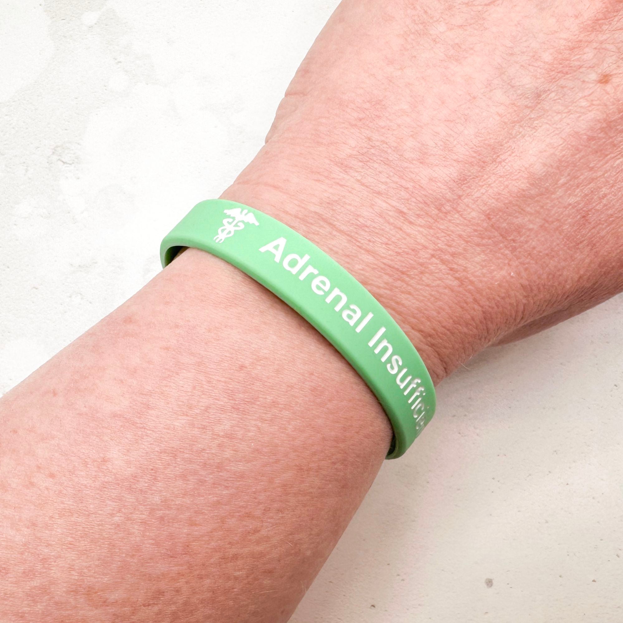 Mint green silicone adrenal insufficiency medical alert wristband worn on wrist 