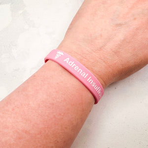 pink silicone adrenal insufficiency medical alert wristband worn on wrist