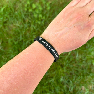 Person wearing an anaphylaxis alert silicone medical bracelet on the wrist for everyday allergy safety