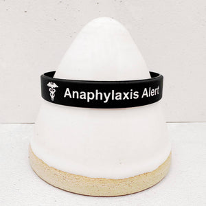 Close-up of an anaphylaxis alert wristband showing clear medical identification text