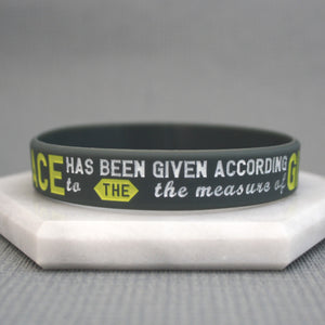 Grey wristband with motivational quote on a gray background