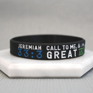 black band with white, blue, and green text against a grey background