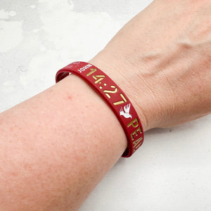 red band with gold text worn on a wrist