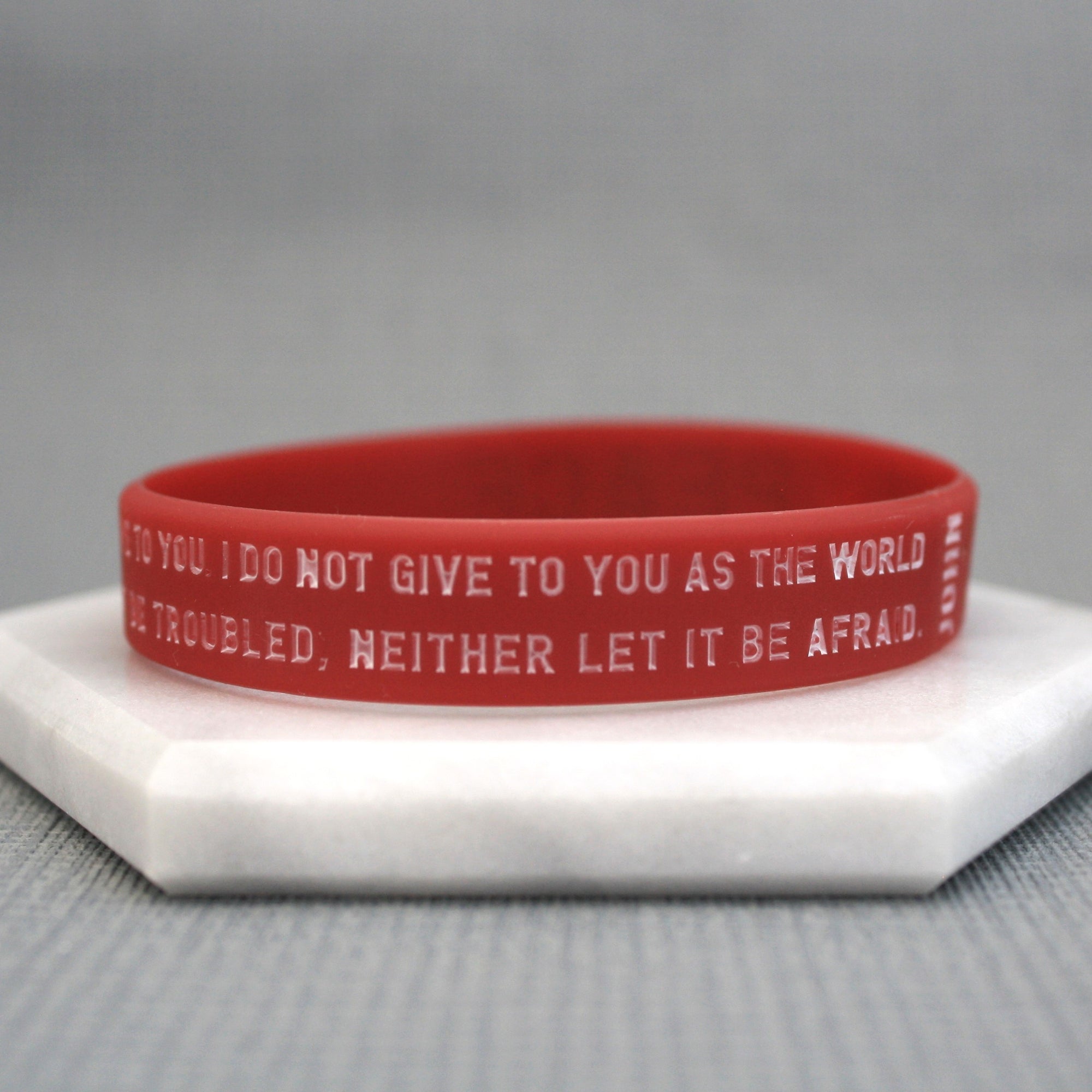 Red wristband with text on a gray background