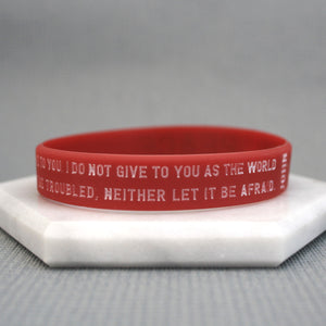 Red wristband with text on a gray background
