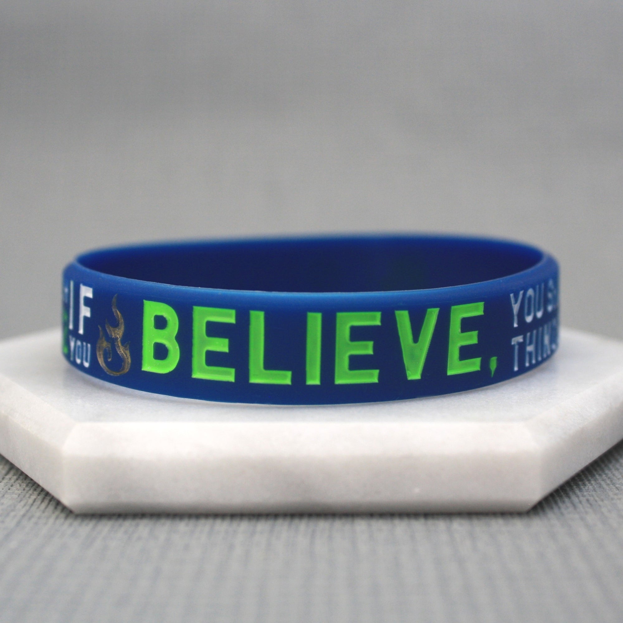 Blue wristband with green text on a gray background