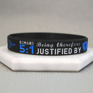 Black wristband with text on a white surface
