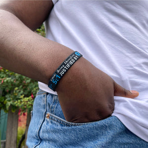 Person wearing a bracelet with text on wrist, blurred background