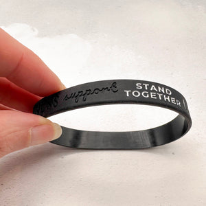 black silicone wristband engraved with ‘support stand together'