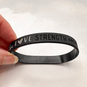 black silicone wristband engraved with ‘love strength’ 