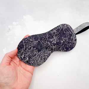 Sleep mask with pattern held by a hand 