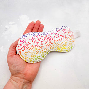 Hand holding an eye mask with colourful male anatomy pattern 