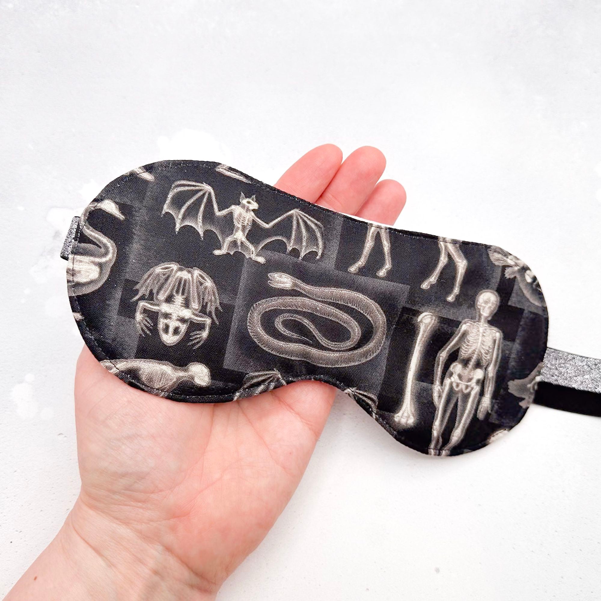 Sleep mask with x-ray animal design held in a hand