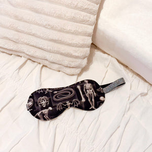 Sleep mask with skeleton design on a white bed