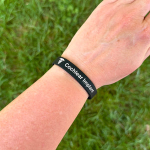 Person wearing a cochlear implant silicone medical bracelet on the wrist for everyday safety