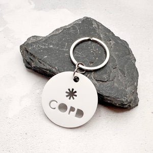lightweight white acrylic round keychain with 'COPD' laser cut out