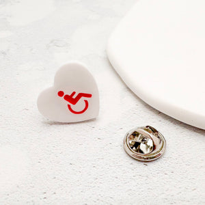 white acrylic heart pin with disabled symbol in red