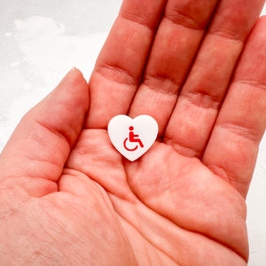 white acrylic heart pin with disabled symbol in red