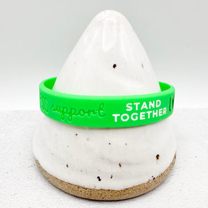green awareness ribbon wristband with "support stand together" text engraved on the side