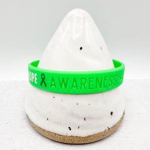 green awareness ribbon wristband with "hope & awareness" text engraved on the side