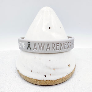 grey awareness ribbon wristband with "hope & awareness" text engraved on its side 