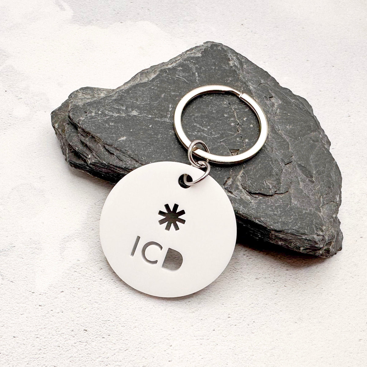 lightweight white acrylic round keychain with 'ICD' laser cut out