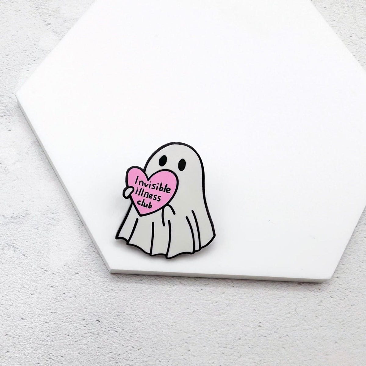 Ghost pin holding a pink heart with 'Invisible Illness Club' text on a white background