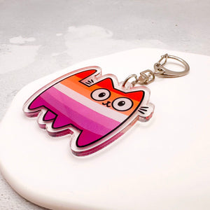 A colourful acrylic keychain featuring a cartoon cat lesbian stripes, attached to a silver metal split ring
