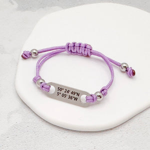 latitude longitude bracelet with purple nylon cord and a stainless steel tag with grid coordinates