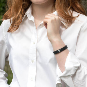 Person wearing a black wristband with a white shirt