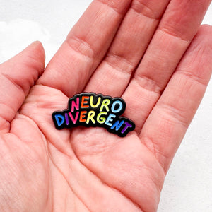 rainbow enamel pin with 'Neurodivergent' text held in hand
