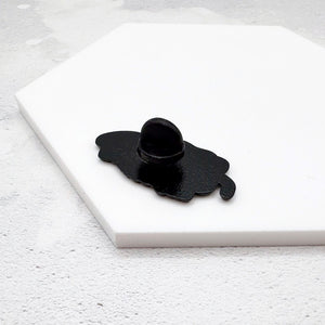 Neurospicy chilli pin face down on a white surface