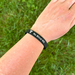 Person wearing a 'No Blind NG' silicone medical bracelet on the wrist for everyday safety