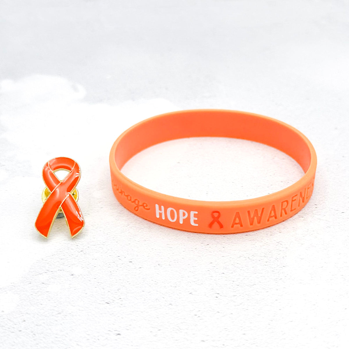orange silicone wristband engraved with ‘Hope & Awareness’ besides matching orange enamel ribbon pin