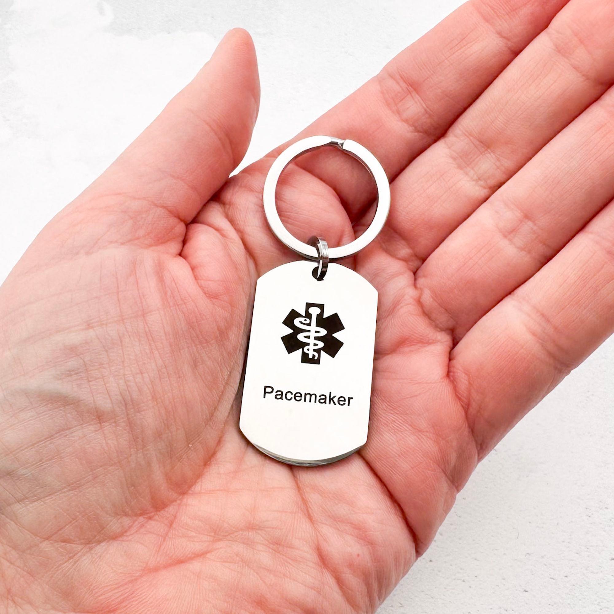 stainless steel keychain with star of life medical symbol and 'Pacemaker' text held in hand