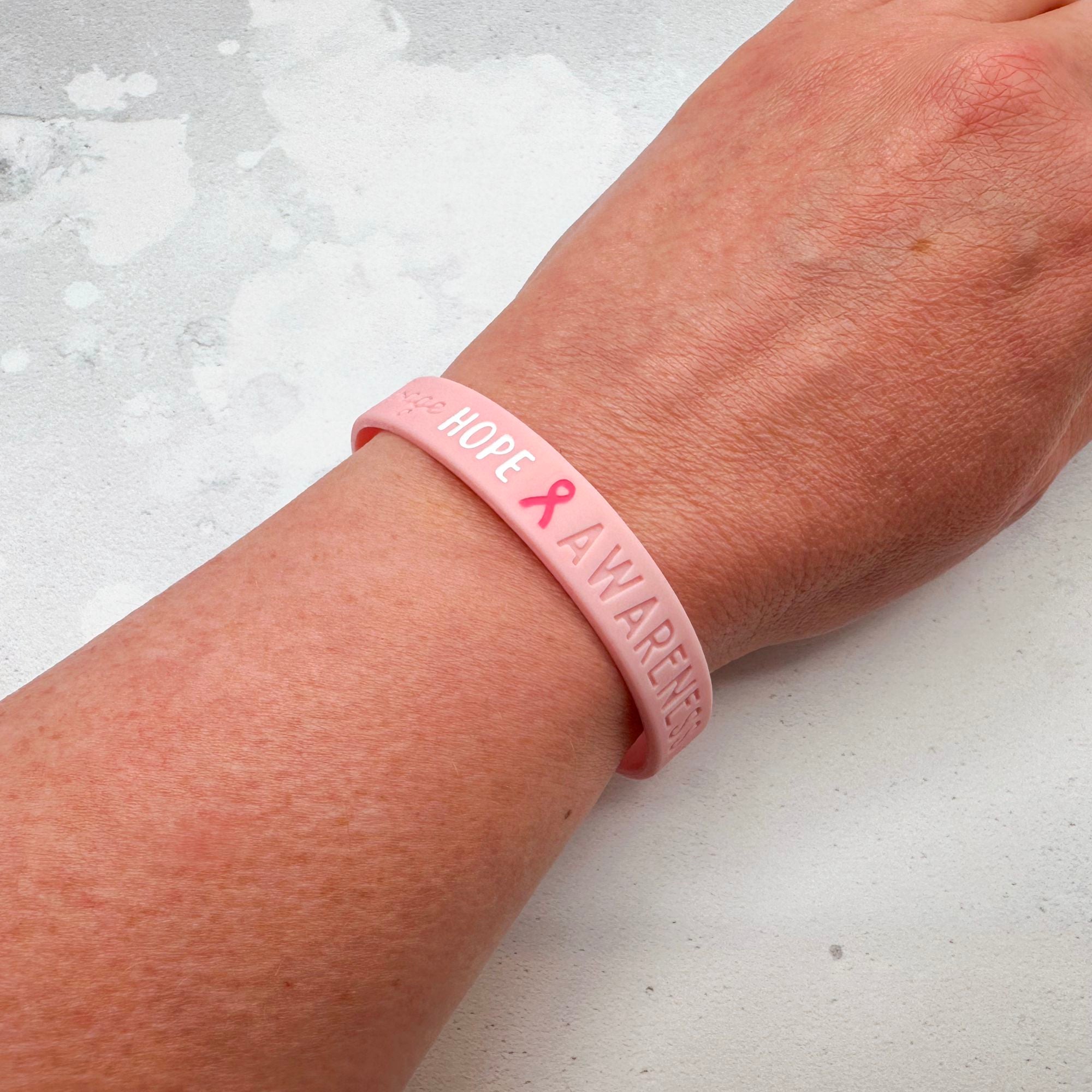 pink silicone wristband engraved with ‘Hope & Awareness’ worn on a person's wrist