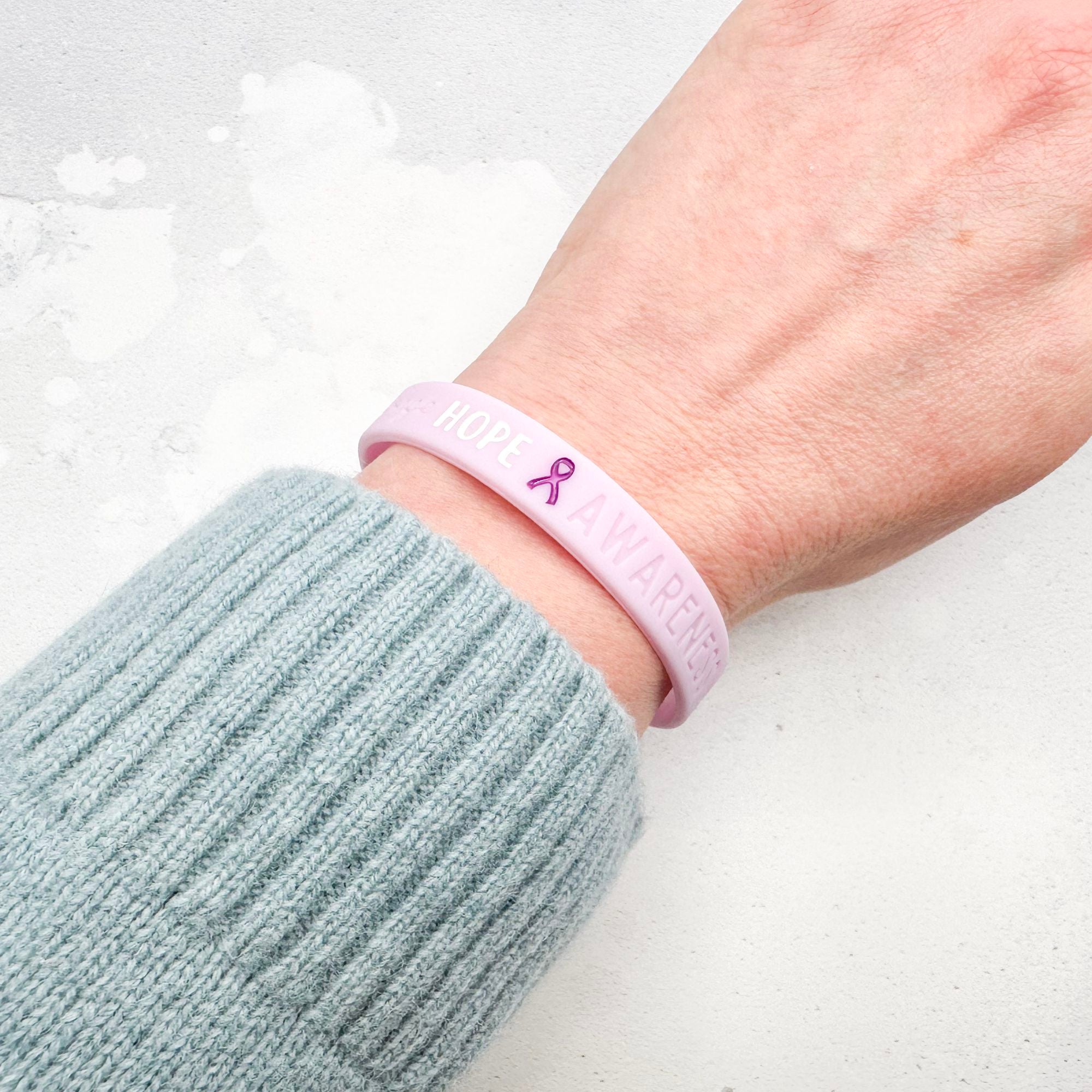 purple silicone wristband engraved with ‘Hope & Awareness’ worn on person's wrist