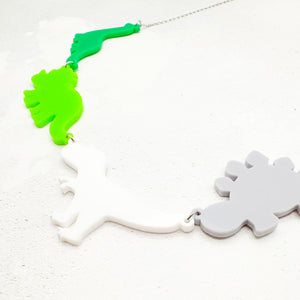 Necklace with dinosaur-shaped pendants in the aromantic colours on a light background