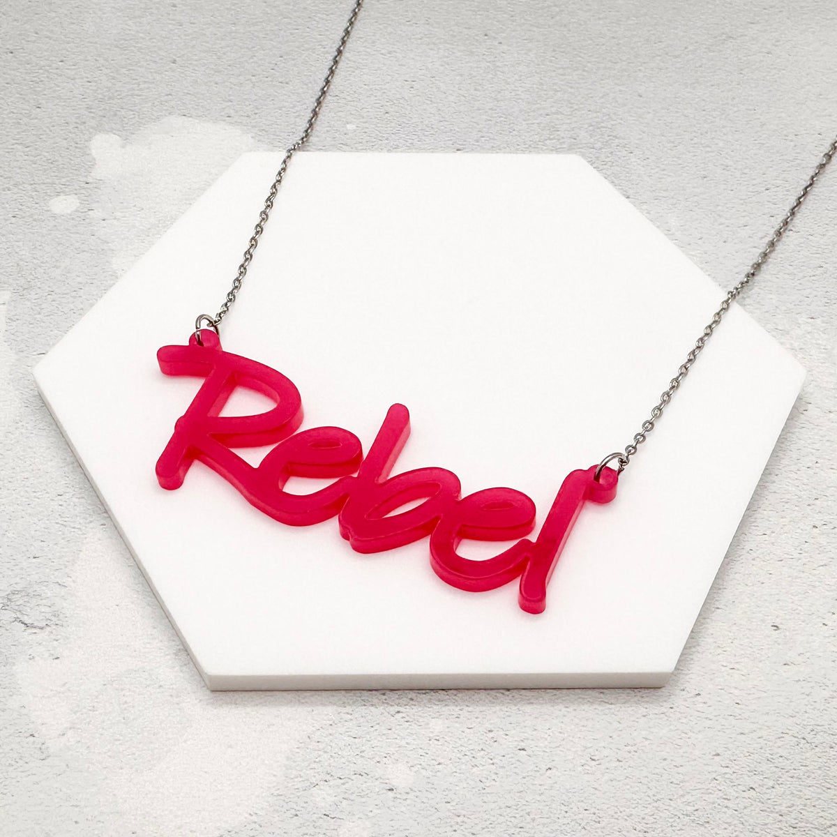 handmade acrylic hot pink rebel necklace on a stainless steel chain