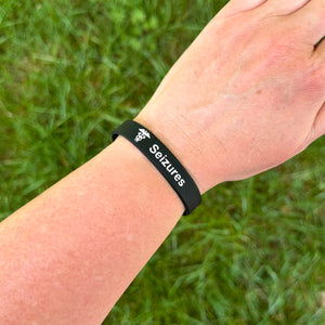 Person wearing a seizure alert silicone medical bracelet on the wrist for everyday epilepsy safety