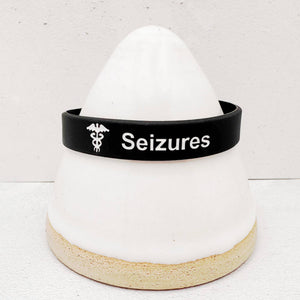 Close-up of a seizure alert wristband showing clear medical identification text