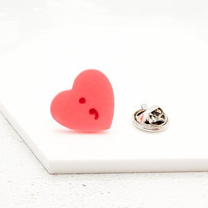 Heart-shaped pink lapel pin with a semicolon symbol